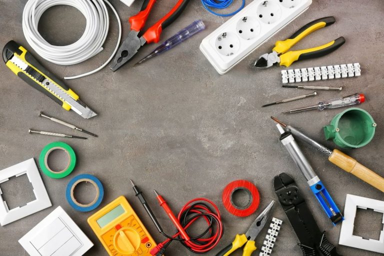 An assortment of electrical tools displayed on a table, featuring pliers, screwdrivers, and other essential equipment.
